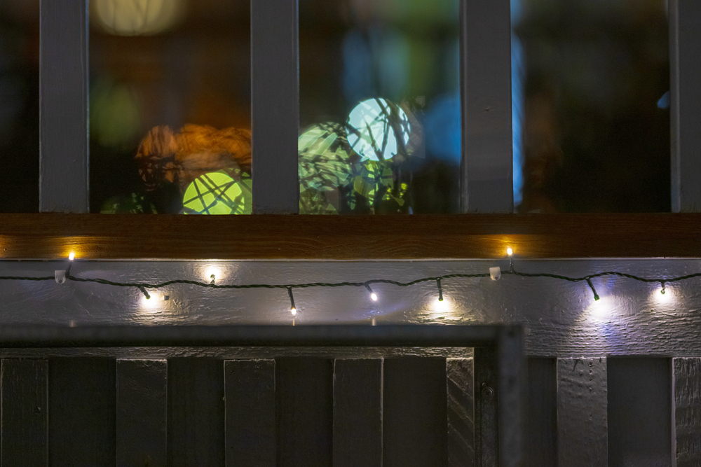Festoon lights creating a warm outdoor entertaining area under a pergola